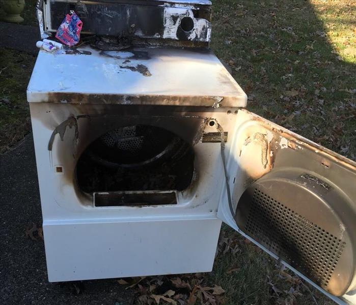 white clothes dryer with scorch marks from fire
