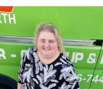 Female office manager in front of green van